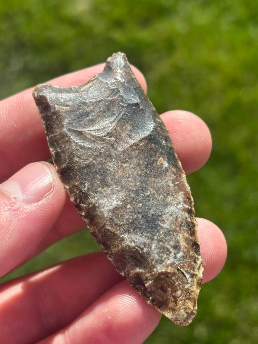 River Candy Clovis reverse face held tip downward, with a close view of the base and flake scars.