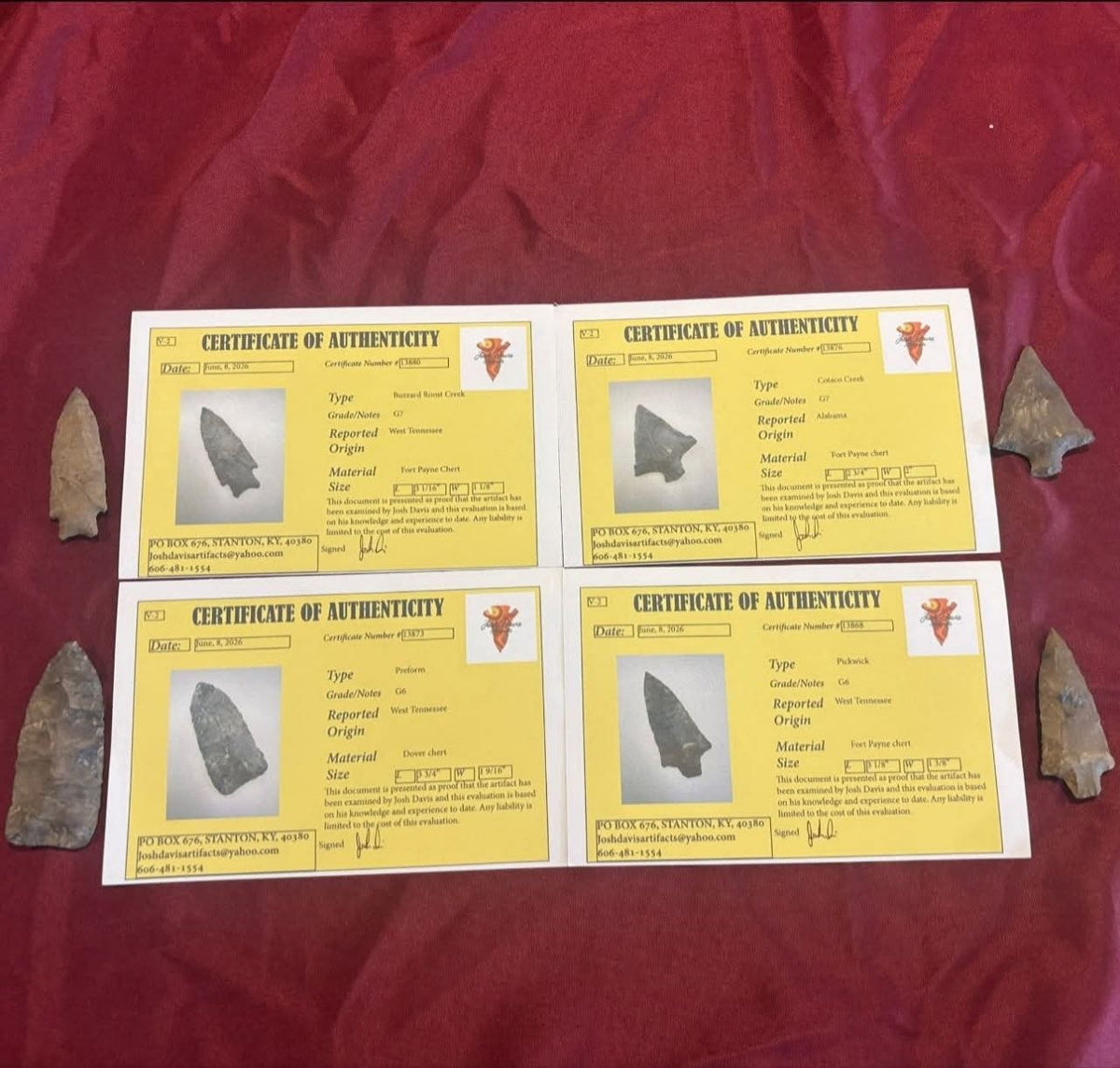 Four stone points from the Tennessee and Alabama lot displayed with their four certificates of authenticity on red fabric.