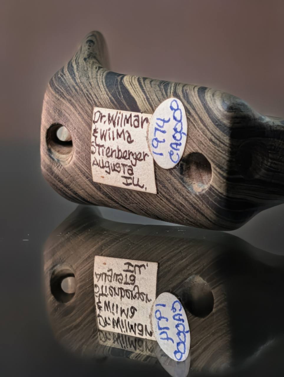 Underside of the Illinois Popeye birdstone showing two basal holes and handwritten collector labels
